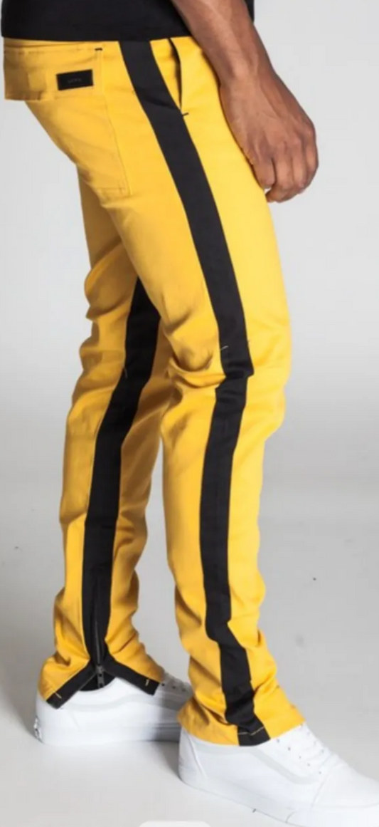 yellow pants with black stripes on the sides with zippers at the bottom ends